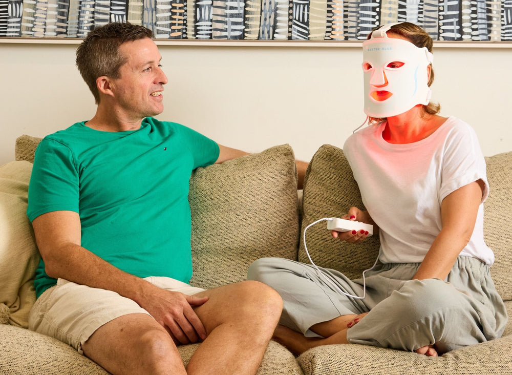 Baxter_Blue_Red_Light_Therapy_Face_Mask_woman with mask on holding controller with a man