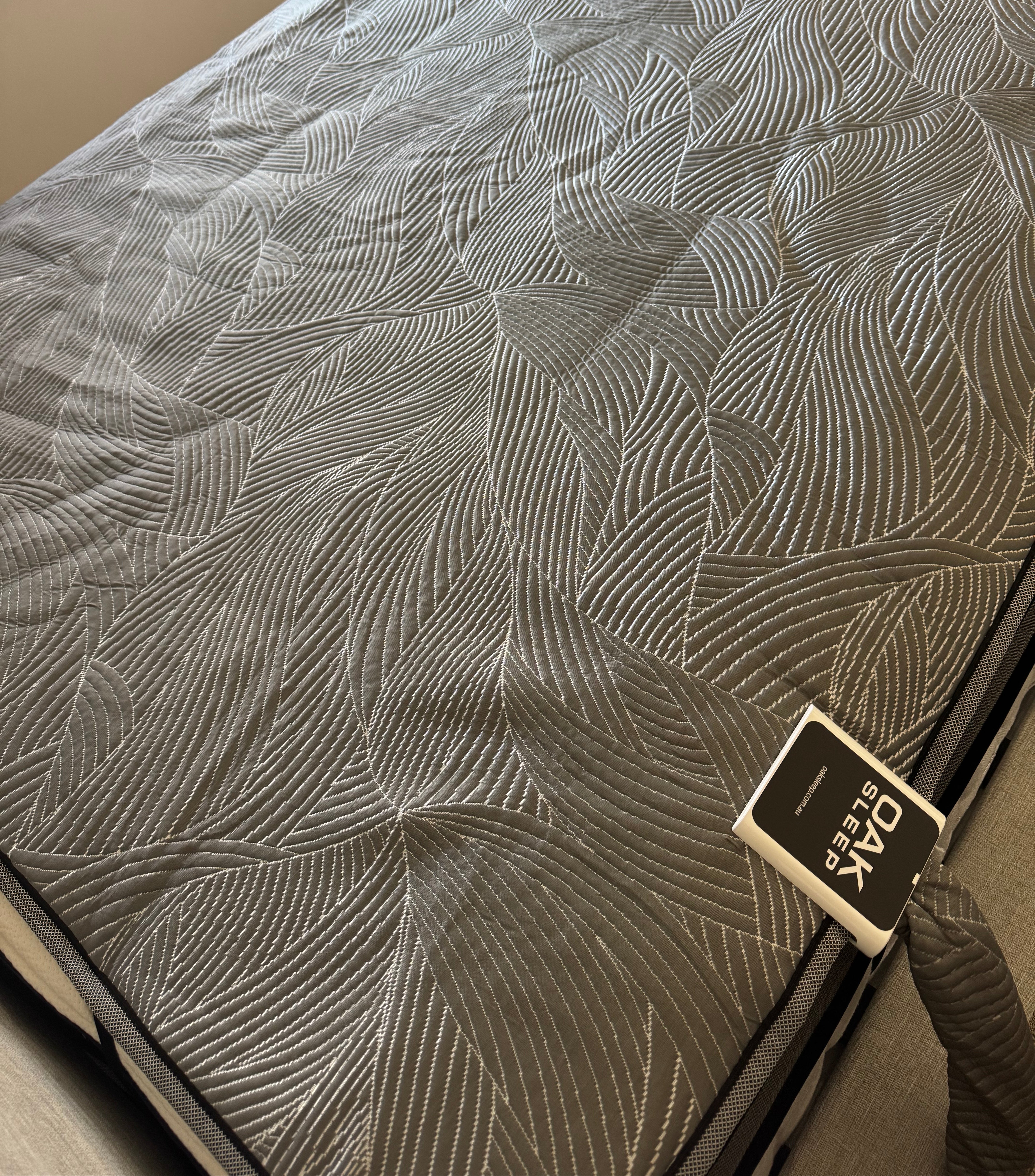 Textured mattress cover with brand tag on a bed
