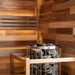 Close-up of traditional sauna heater with stones inside a 2-person outdoor sauna