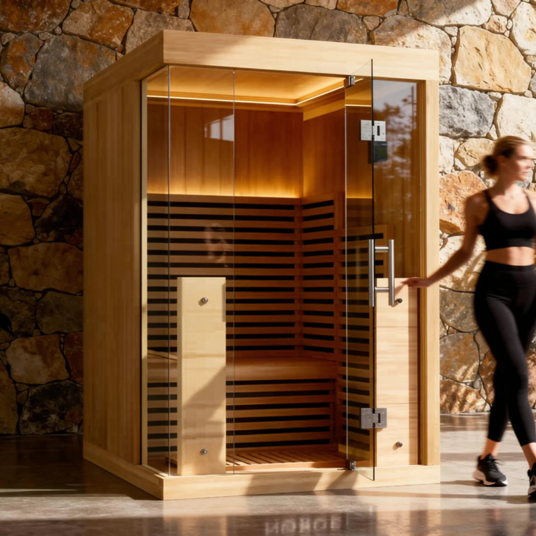 A 2-person indoor infrared sauna in a home setting with a woman standing next to it